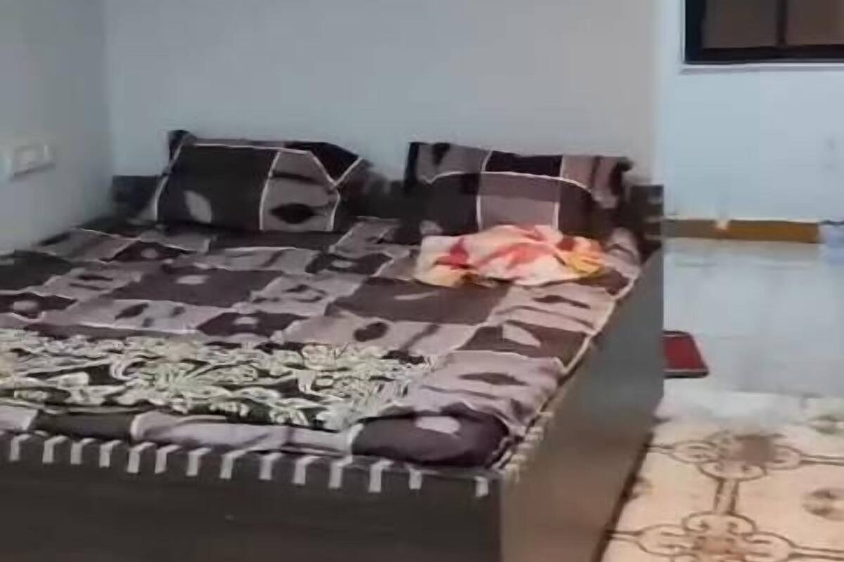 A bedroom with a large bed, a ceiling fan, and a patterned floor.