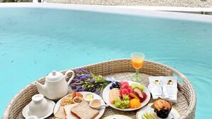 A breakfast setup by a pool with a view of a hilly landscape. - Kiri Rhom Khao Kho (Khao Kho)