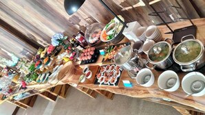 A long wooden table with various food items and utensils, likely set up for a communal meal. - Kiri Rhom Khao Kho (Khao Kho)