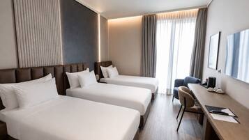 Habitación triple Deluxe, balcón, vista a la ciudad | Minibar, caja de seguridad en la habitación y escritorio