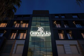 A hotel named 'GrandBuka' with a modern glass facade, visible windows, and a logo. - Grand Duka Hotel & Spa (Durrës)