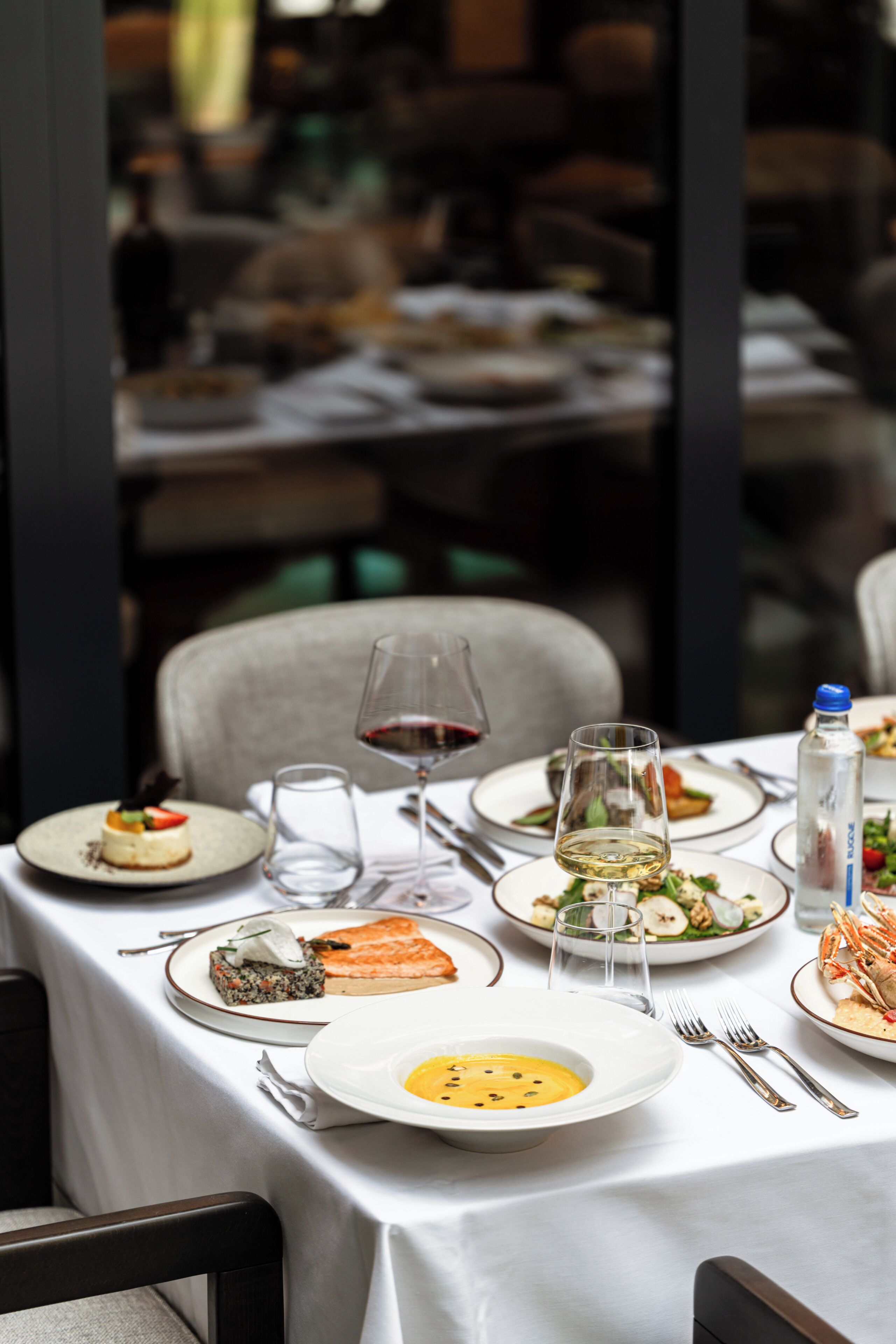 A dining table set with various dishes, glasses, and cutlery, indicating a restaurant setting.