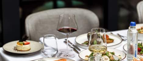 A dining table set with various dishes, glasses, and cutlery, indicating a restaurant setting.