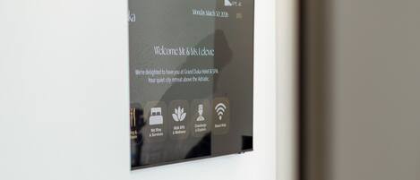 A modern reception desk with a digital screen displaying welcome messages and hotel amenities.