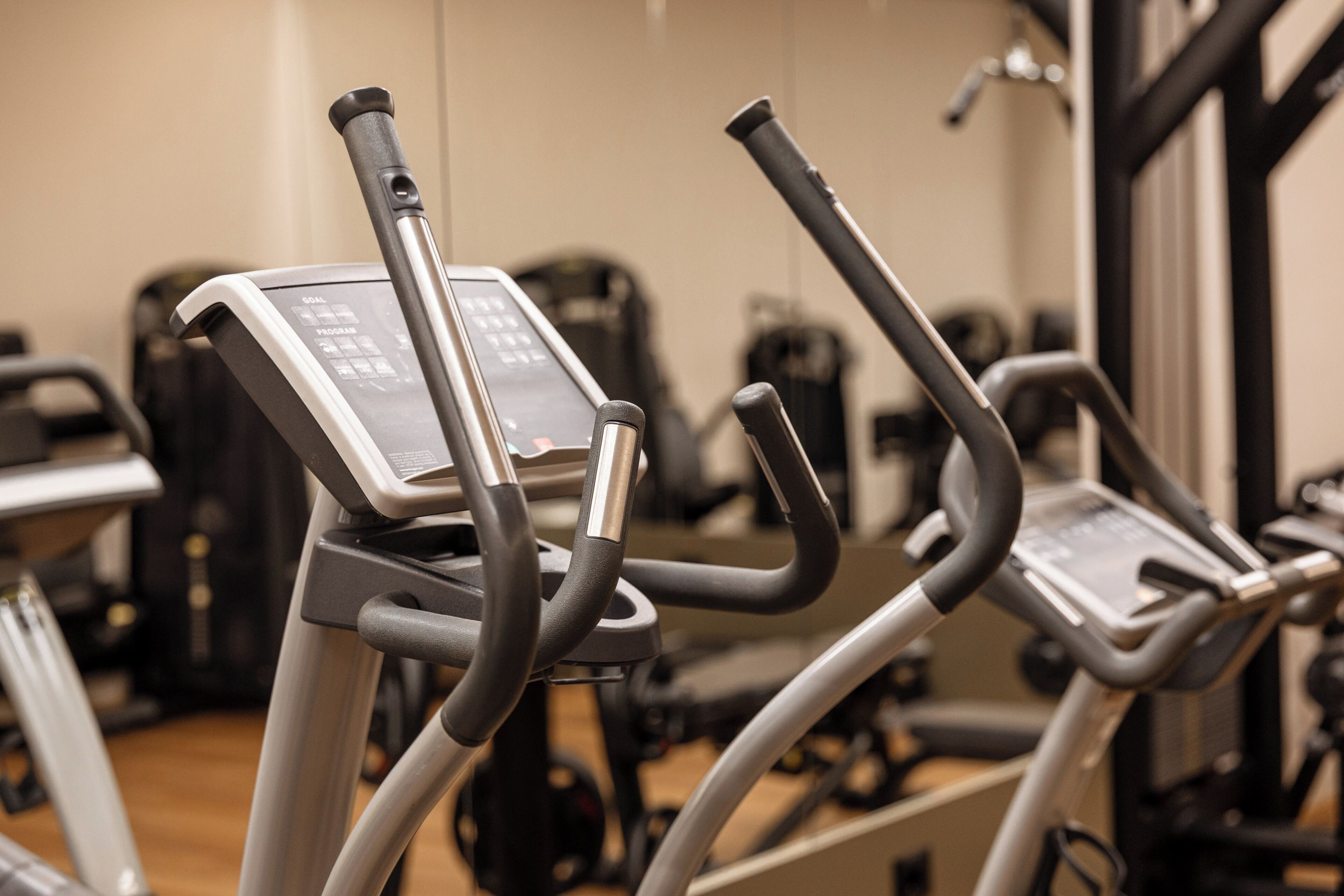 Fitnessapparatuur in een sportschool, inclusief een bedieningspaneel, handvaten en een beeldscherm.