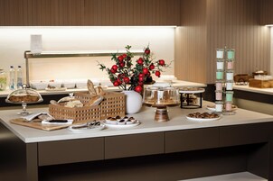 Un buffet garni de divers plats, agrémenté d’une plante décorative et d’un porte-bougie.