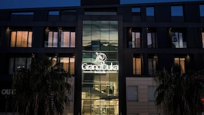 Ein Hotel mit auffälligem Schild, auf dem 'GrandDuka Hotel & Spa' steht, und einem modernen architektonischen Design.