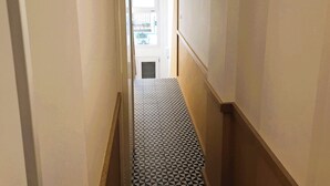 A narrow hallway with patterned flooring and wooden trim. - CASA MORETTI (Bari)