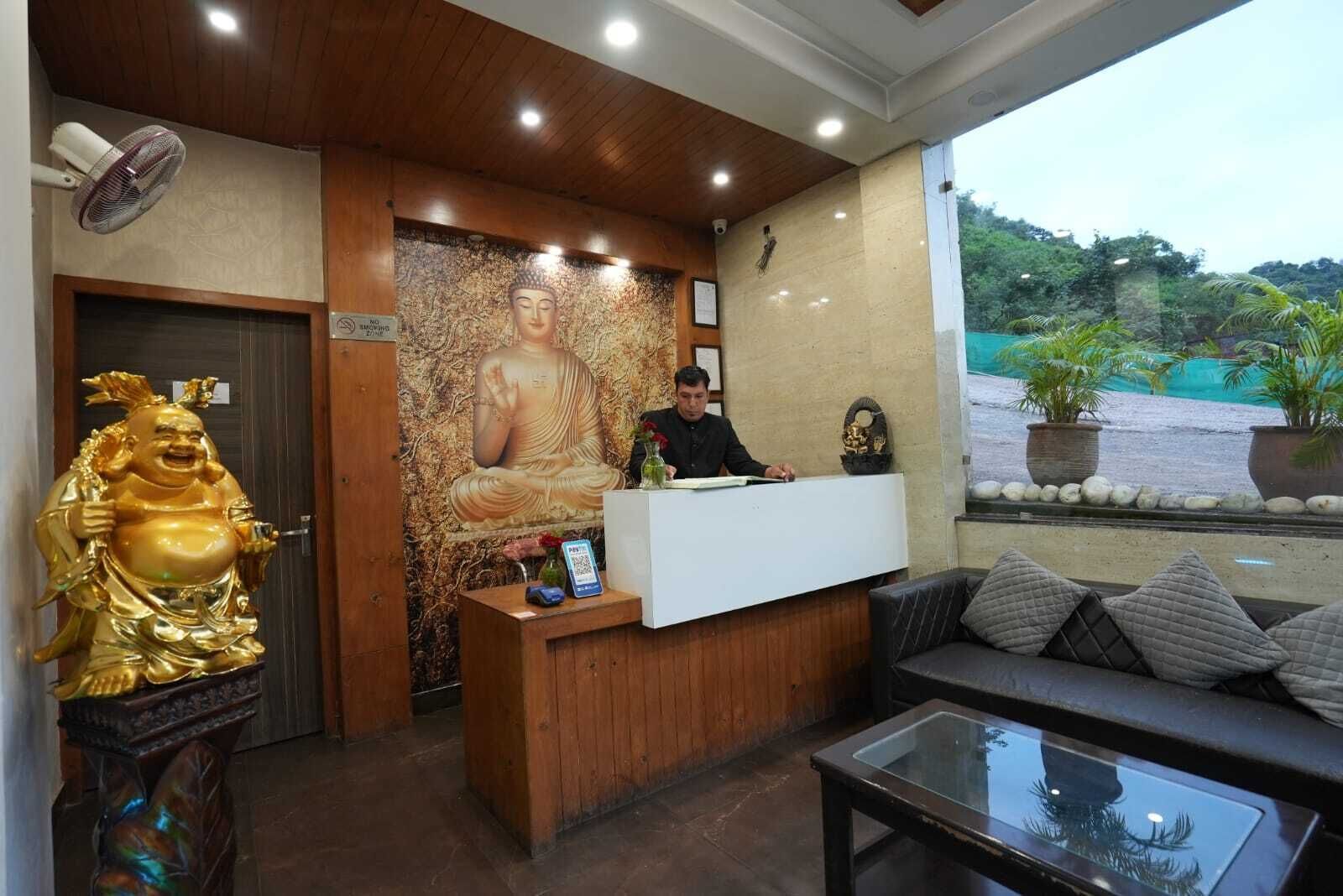 Un área de recepción con una estatua de Buda, un mostrador de recepción y un sofá.