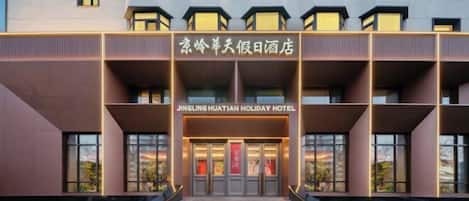 L'ingresso moderno di un hotel con un cartello ben visibile che riporta la scritta "JINGLING HUATIAN HOLIDAY HOTEL".