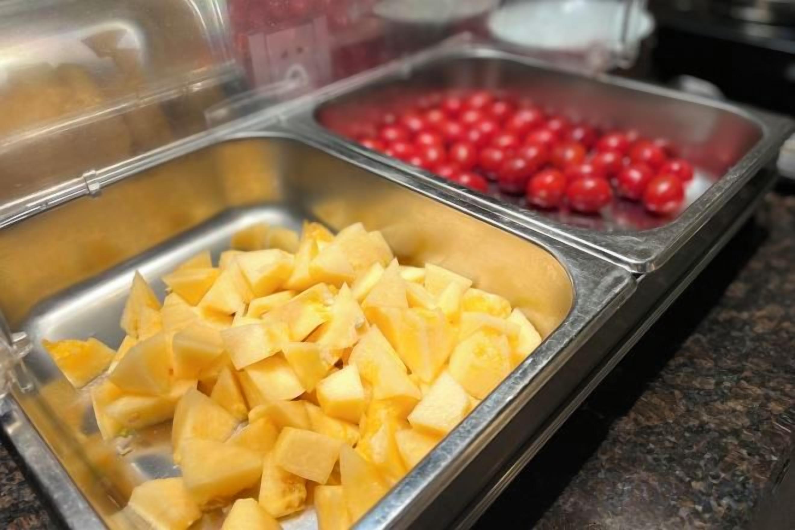 A buffet with various food items in metal containers.