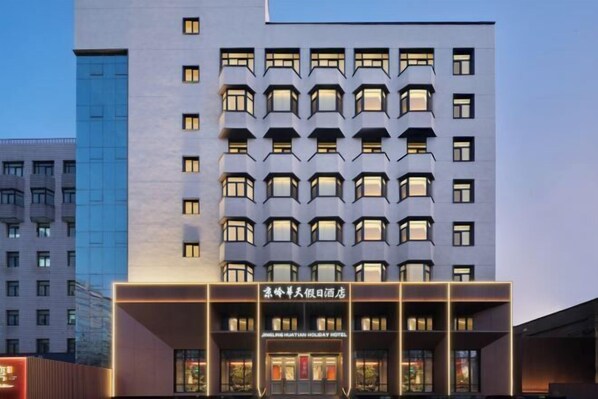 A modern hotel building with multiple floors and a prominent entrance. - Jingling Huatian Holiday Hotel (Capital Gymnasium Baishiqiao South Subway Station) (Beijing)