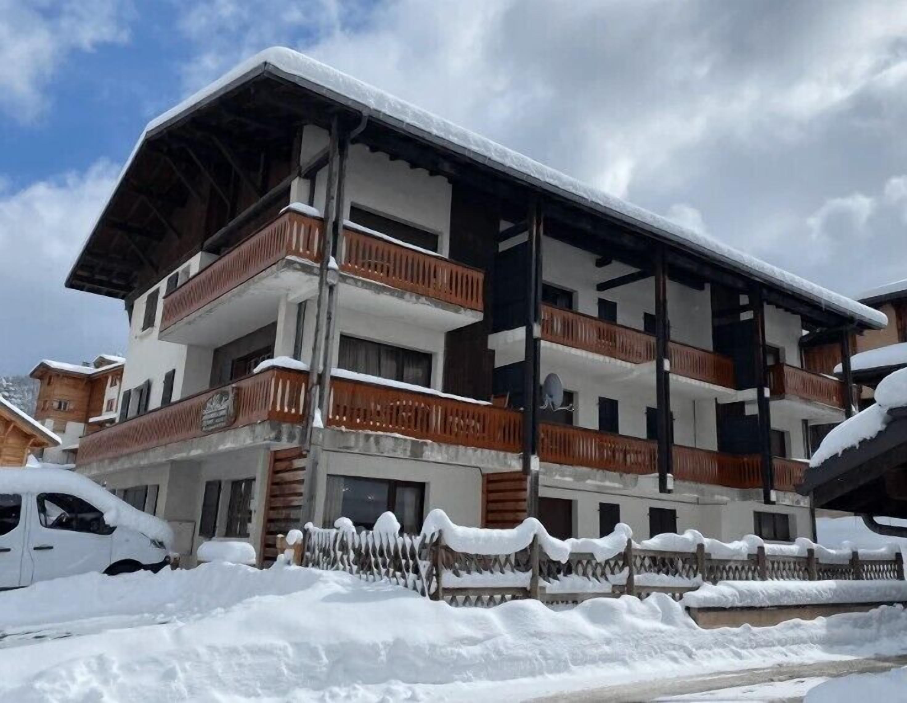 Un immeuble à plusieurs étages doté de balcons, entouré de neige.