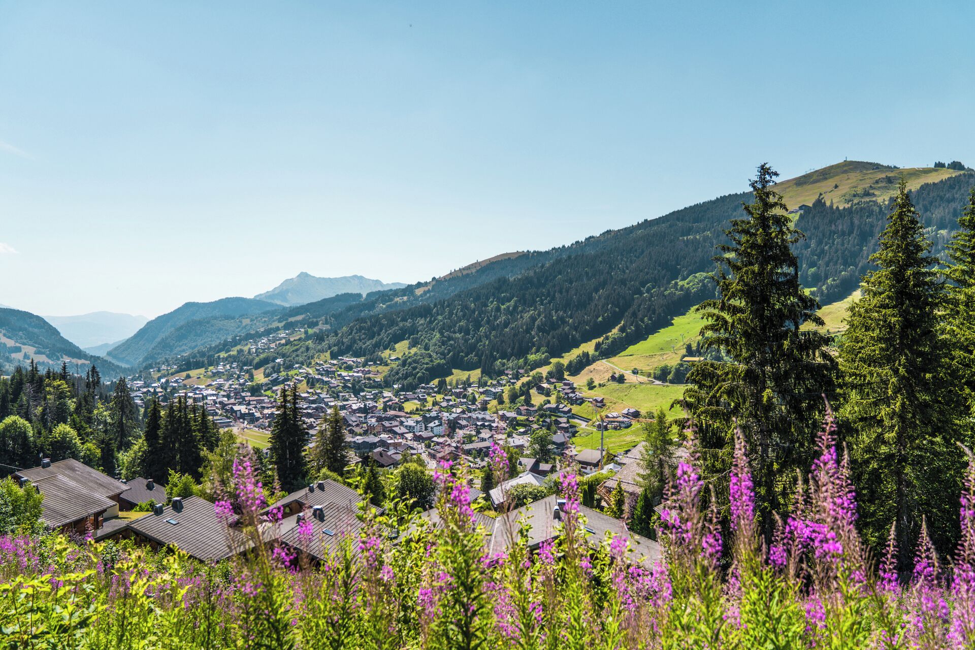 A mountain village with houses and a clear view of the surrounding hills.