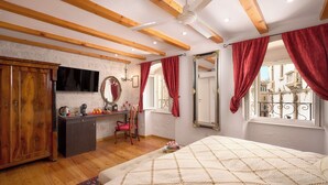 A bedroom with a bed, wooden beams, a desk, a chair, a mirror, and a window with red curtains. - Sun Spalato Ammarulla (Split)