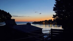 A waterfront property with a view of the sea, a dock, and a building with a sloped roof. - Pretty house at the foot of the beach - Jacuzzi (Guidel)