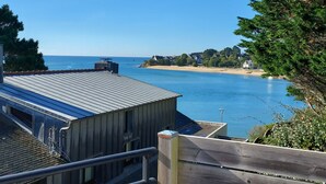 A coastal view with a clear sky, a sandy beach, and a body of water. - Pretty house at the foot of the beach - Jacuzzi (Guidel)