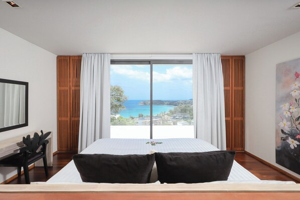 A bedroom with a large bed, a desk, and a view of the sea. - Panoramic View The Heights Kata Beach B1 (Muang)