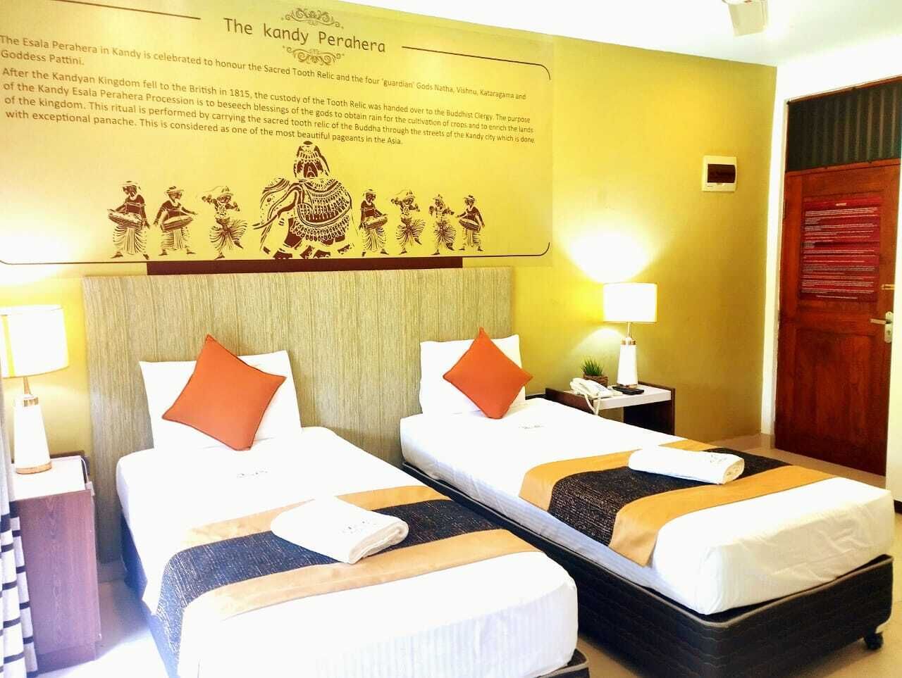 A hotel room with two beds, a wall-mounted artwork depicting a cultural scene, and a wooden door.