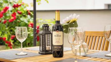 A bottle of wine, glasses, and a lantern on a wooden table with a flower.