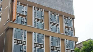 A multi-story building with a beige facade, large windows, and air conditioning units. - Yeste Hotel (Yulin Culture Square) (Yulin)