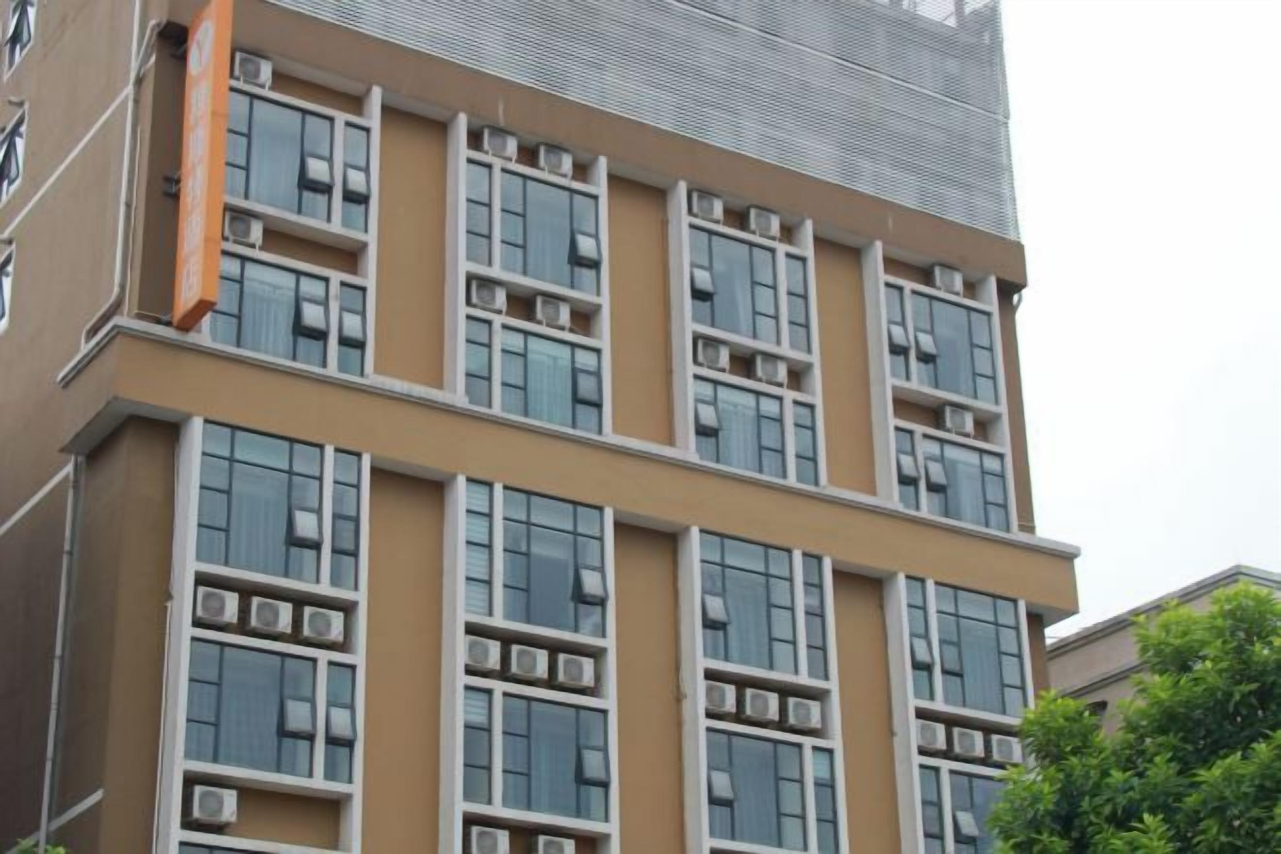 A multi-story building with a flat facade, large windows, and air conditioning units.