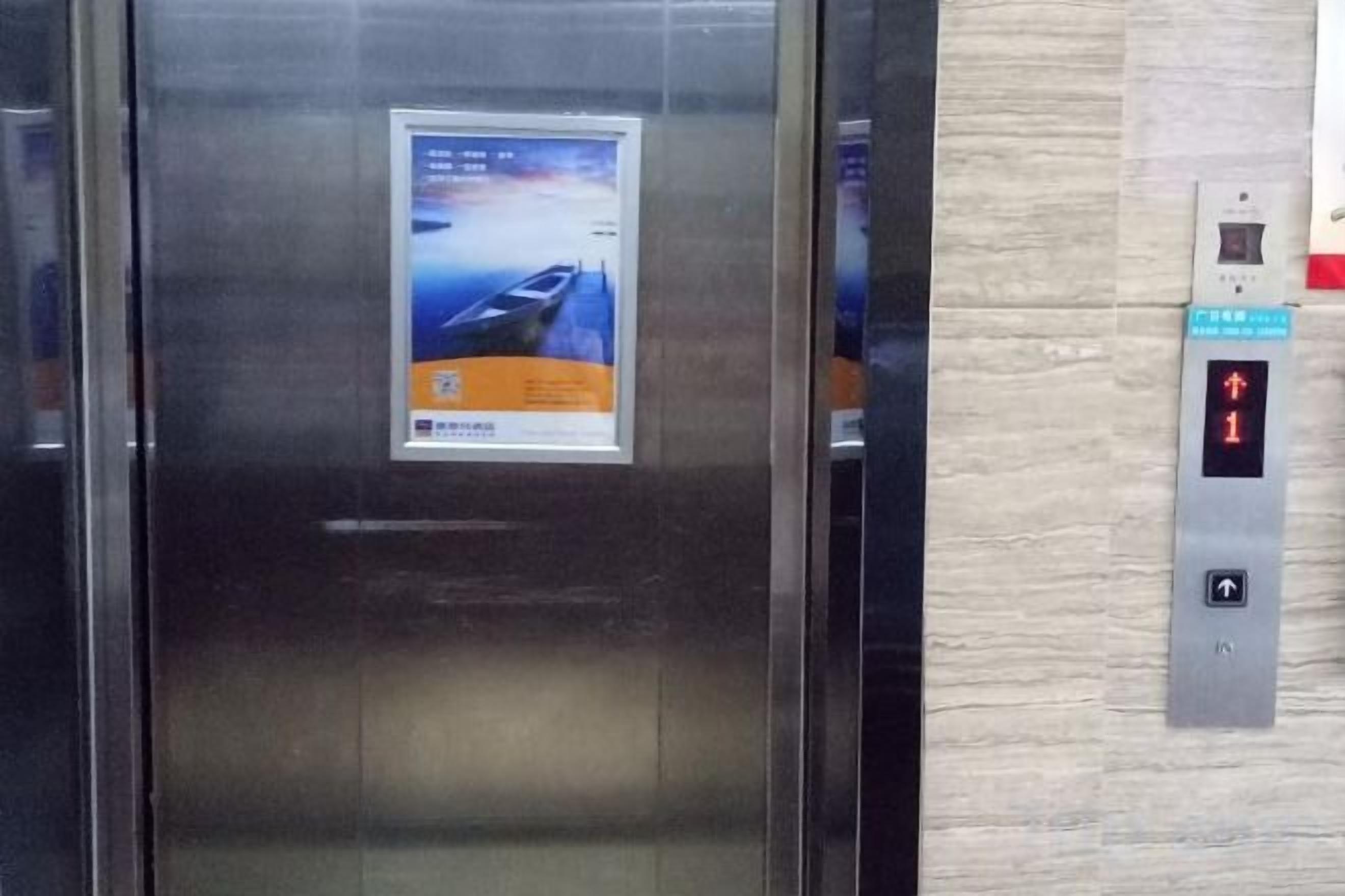 An elevator with a digital display and a poster on the door.