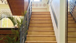 Un escalier en bois avec des rampes en métal, menant à l’étage supérieur.