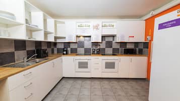 A modern kitchen with white cabinets, a checkered backsplash, and a 'For Guests' fridge sign.