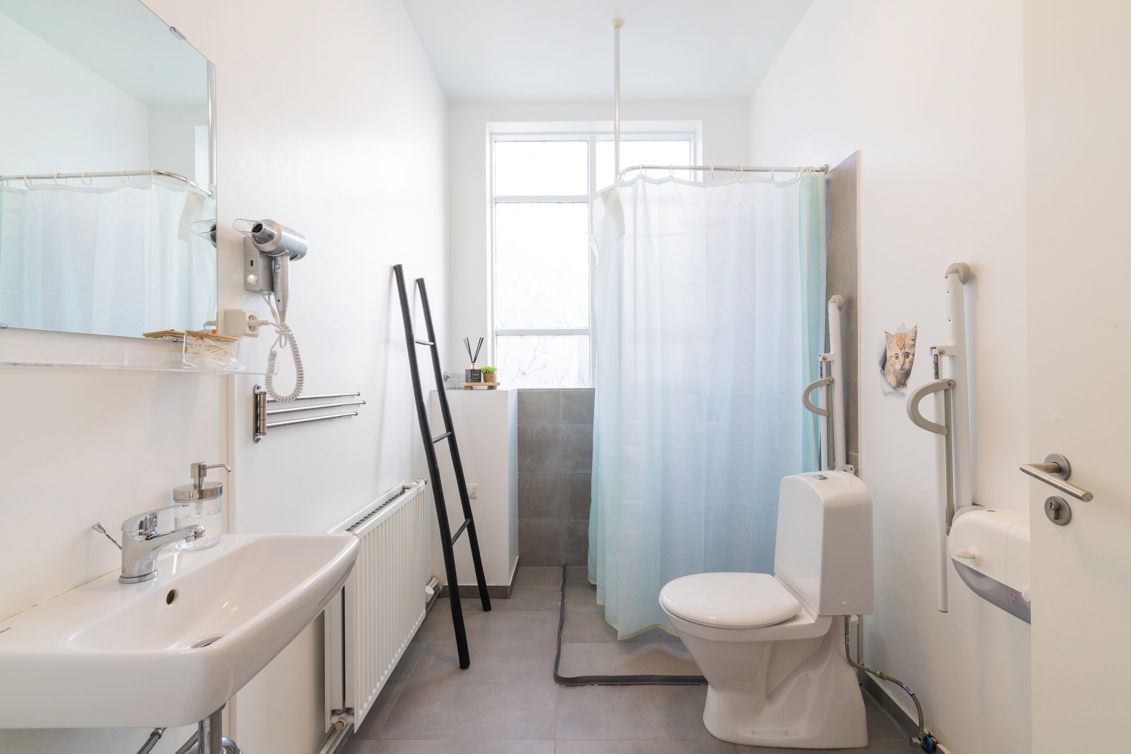 A bathroom with a sink, toilet, and shower curtain.