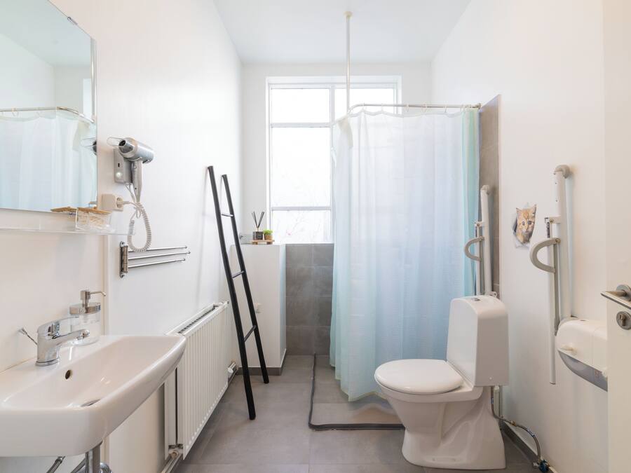 A bathroom with a sink, toilet, and shower curtain.