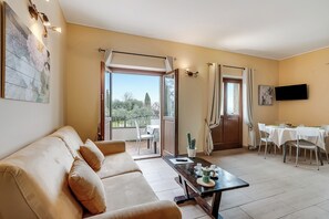 Family Apartment, 1 Bedroom (One Bedroom Apartment Cascina) | Living area | 21-inch flat-screen TV with satellite channels - Cascina Crocelle Apartments (Padenghe sul Garda)