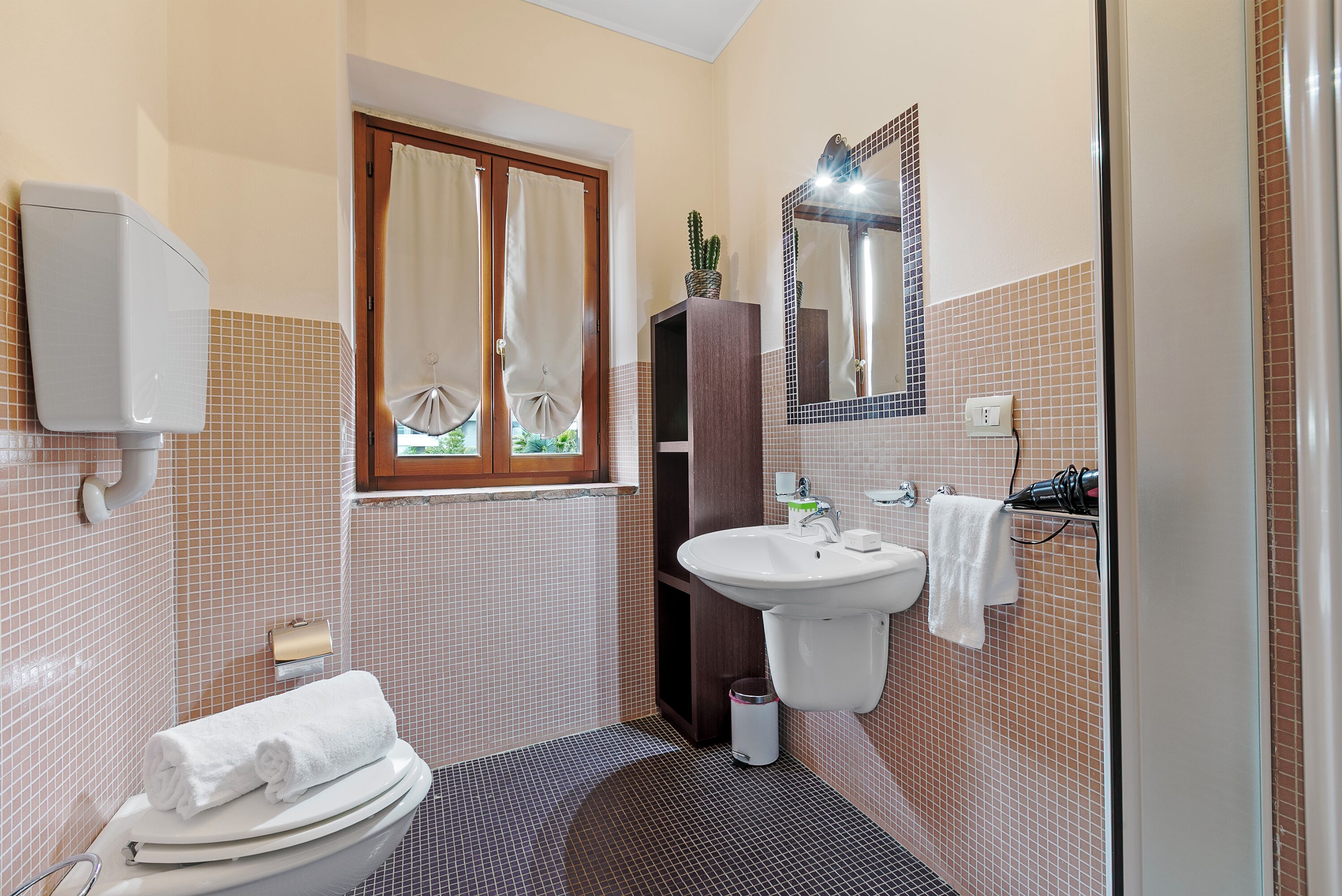 Une salle de bain avec des toilettes, un lavabo et un miroir.