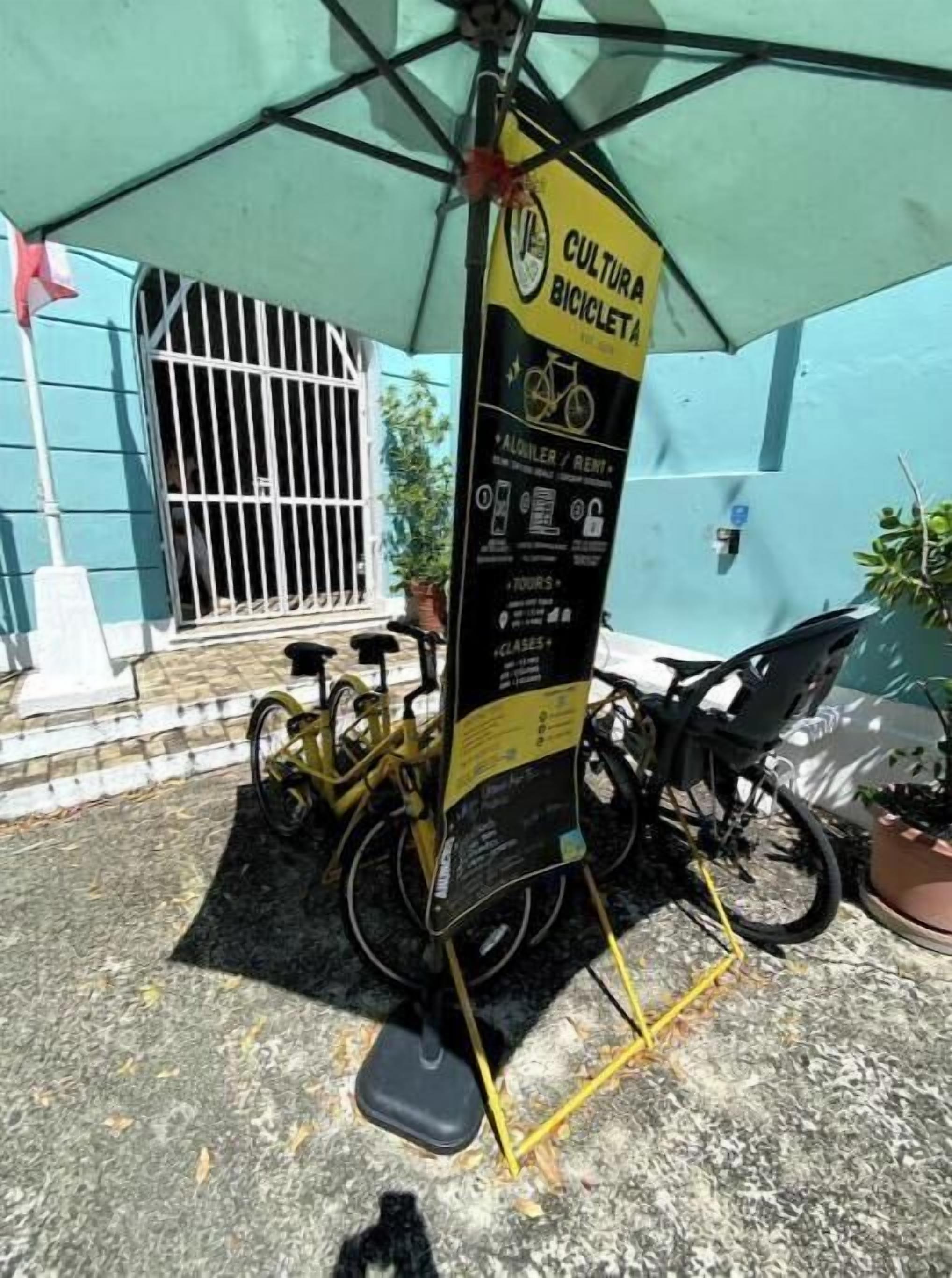 Un point de location de vélos avec une pancarte indiquant qu’il fait partie d’un programme culturel de location de vélos.