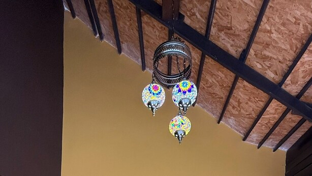 A wooden door with a decorative frame, a tiled floor, and a ceiling with exposed beams. - Kawarin Kanpuri Villas (Kanchanaburi)