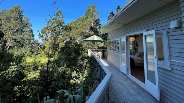 Una casa con terraza que da a un área boscosa.