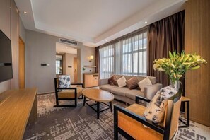 A modern hotel room with a sofa, armchairs, a coffee table, a TV, and a large window with curtains. - Jiyue Crystal Hotel (Nanning Convention and Exhibition Center Qingxiushan Branch) (Nanning)