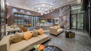 A modern hotel lobby with a central seating area, a reception desk, and a large window offering a view of the city. - Jiyue Crystal Hotel (Nanning Convention and Exhibition Center Qingxiushan Subway Station) (Nanning)
