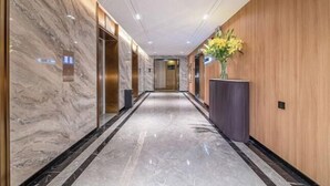 A modern hallway with marble walls, a wooden panel wall, and a marble floor. - Jiyue Crystal Hotel (Nanning Convention and Exhibition Center Qingxiushan Subway Station) (Nanning)