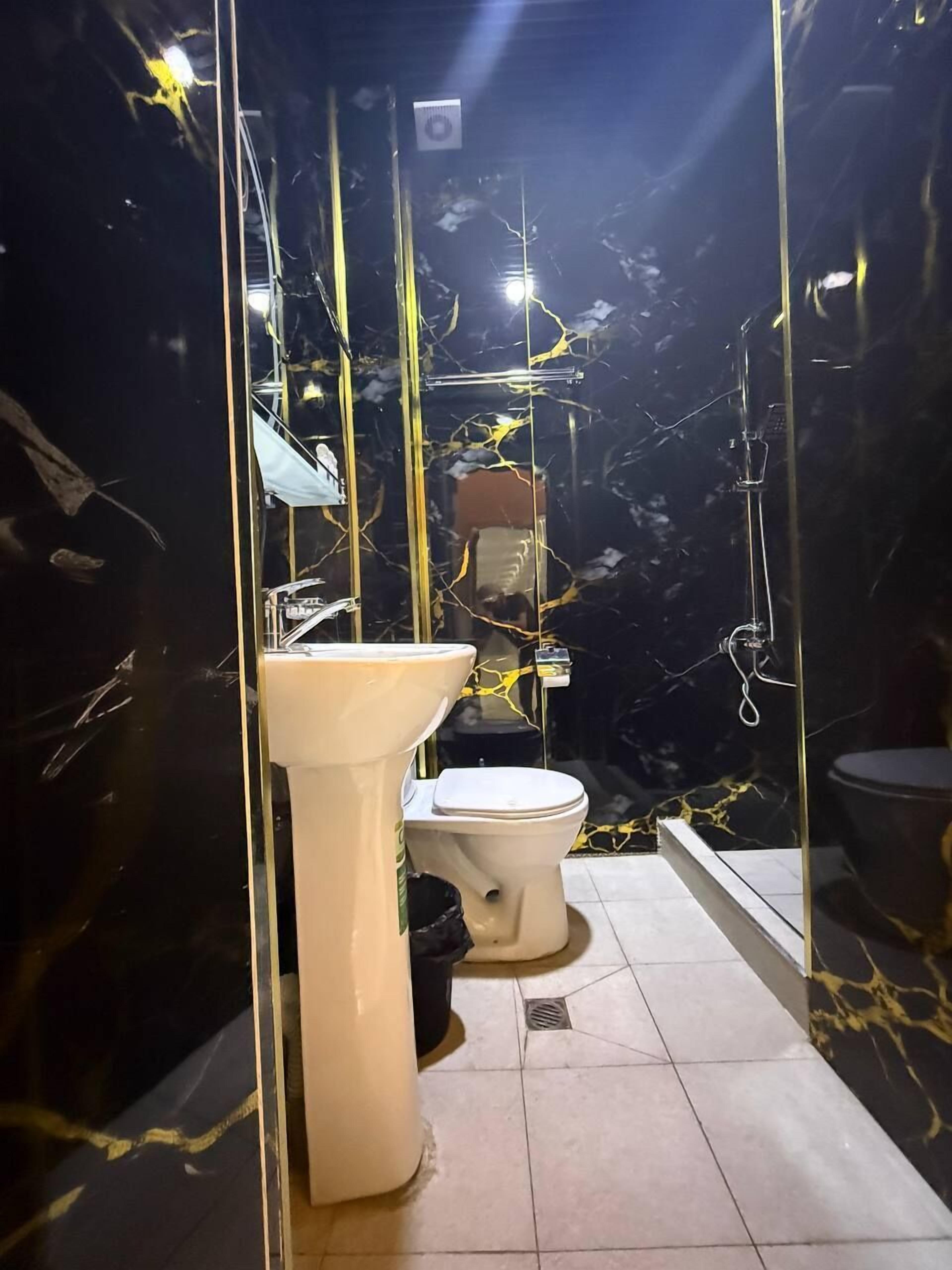 A bathroom with a white sink, toilet, and bathtub. - Safo Hotel (Tashkent)