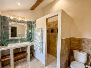 Une salle de bain équipée d’un lavabo, d’un miroir et d’un espace douche.
