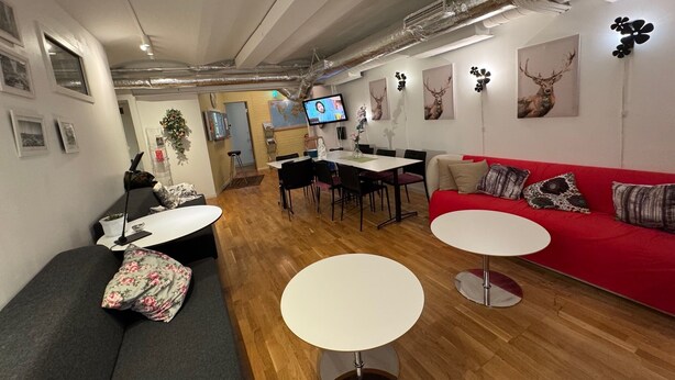 En modern inredning med en röd soffa, en grå divansoffa och en matplats med en tv.