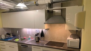 Ett modernt kök med vitvaror i rostfritt stål, en diskmaskin och en diskho.