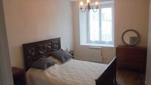A bedroom with a wooden bed, a window with a view, a dresser, and a mirror. - MAGNIFICENT BRETON HOUSE - VIEW OF MONT ST MICHEL - ideal for family reunion. (Sougeal)