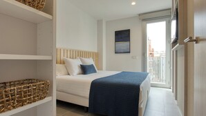 A bedroom with a bed, a window, and a door. - CALM APARTMENTS presents its PREMIUM APARTMENT in the heart of Barcelona. (Barcelona)