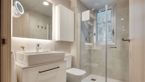A modern bathroom with a glass-enclosed shower, a white sink, and a toilet. - CALM APARTMENTS presents its PREMIUM APARTMENT in the heart of Barcelona. (Barcelona)