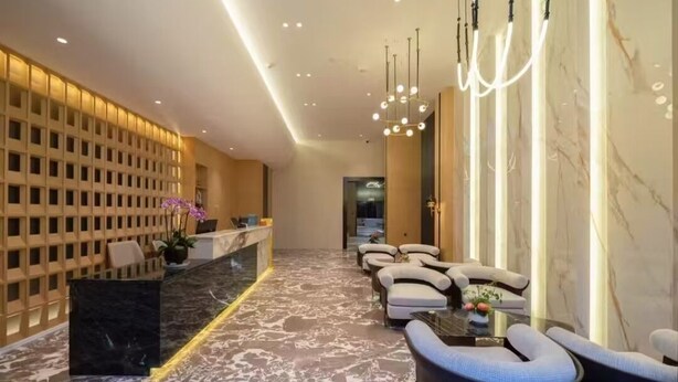 Eine moderne Lobby mit einer Rezeption, einer Sitzecke und einem Marmorboden.
