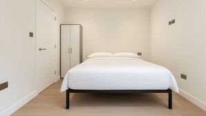 Ein Schlafzimmer mit Bett, Kleiderschrank und Tür.