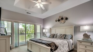 A bedroom with a bed, a nightstand, a ceiling fan, and a view through a sliding glass door to a balcony. - Beautiful World Tour 3B3Ba Condo on 12th Hole. Pool Access. Close to Everything! (Myrtle Beach)