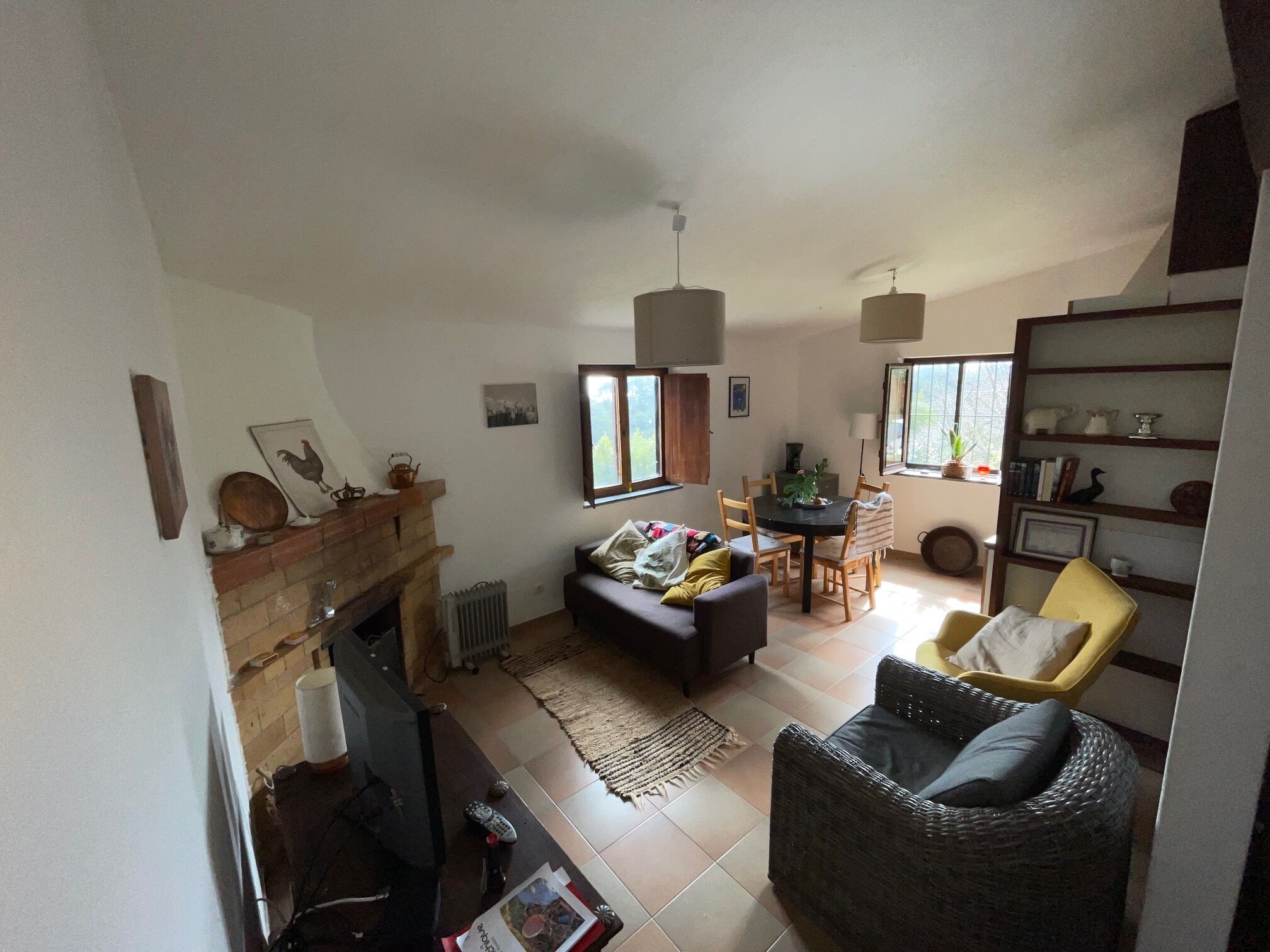 A living room with a fireplace, a dining table, and a sofa.